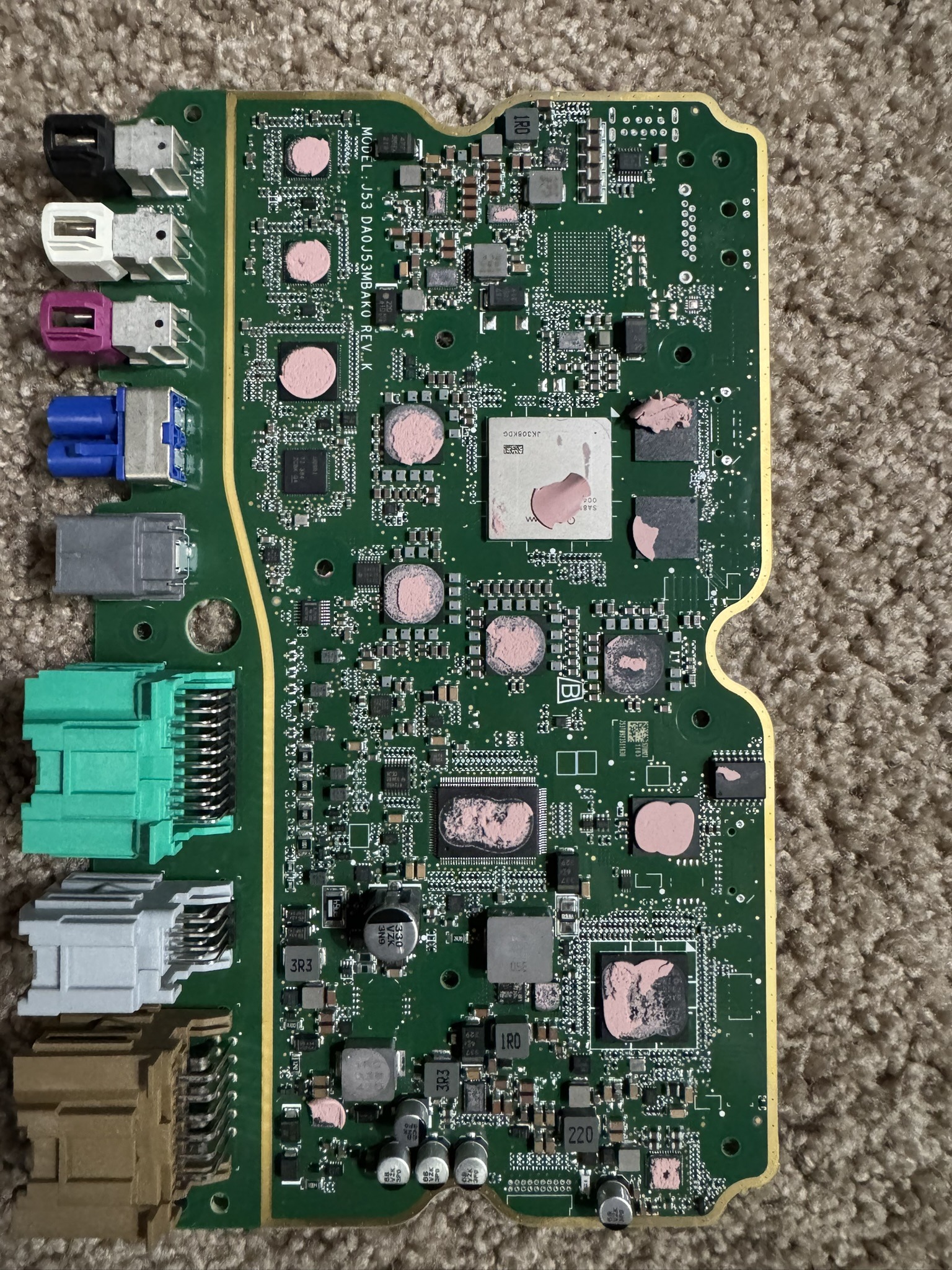 SuperCruise IPM board: a row of colored connectors down the left edge, a large square processor under a metal lid in the center, and pink thermal pad residue on the chips
